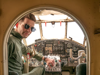 A handsome young pilot sitting in the cockpit