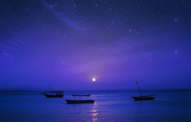 Fotobehang Donkerblauw Sprookjesachtig nachtlandschap Afrika, Tanzania, Zanzibar. Silhouet van vissersboten op de achtergrond van de sterrenhemel in de oceaan
