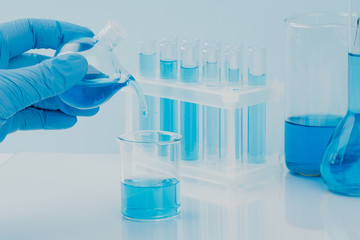 scientific laboratory equipment. hands of a scientific researcher in blue gloves