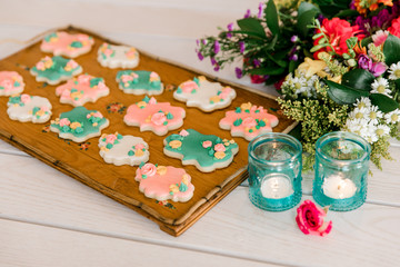 A tray of multi-colored vanilla cookies decorated with cream flowers
