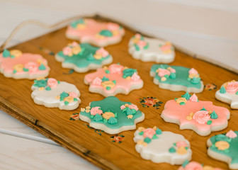 A tray of multi-colored vanilla cookies decorated with cream flowers