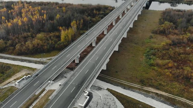An empty highway during the epidemic and quarantine. Aerial view of a four lane bridge over a river with low traffic and traffic density