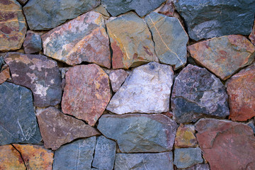 Masonry wall for backdrop. Hollow seams with sharp edges. Different colors of rock.
