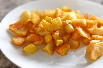 fried golden potatoes on a white plate. Fried potato wedges