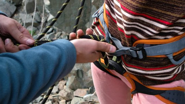 Instructor climber checks outfit on a newcomer for start