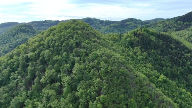 Wide angle dolly in drone shot of beautiful mountains and hills in Suhi Potok settlement in the Municipality of Kocevje in southern Slovenia