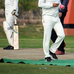 Full length of cricketer playing on field during sunny day, Cricketer on the field in action,...