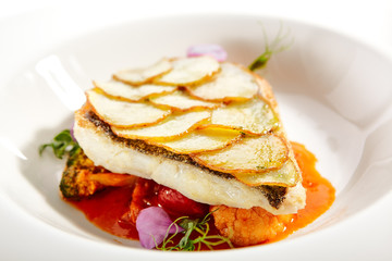 Fried flounder fillet on baked potato slices