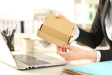 Business woman hands opens package at the office