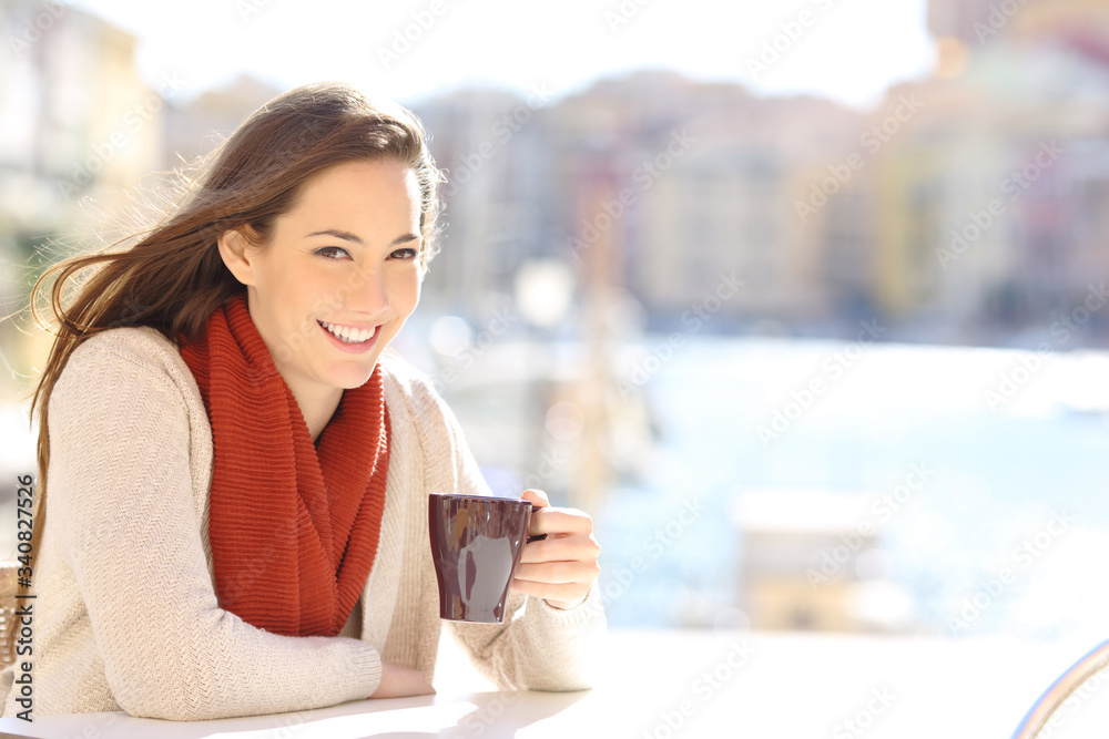 Wall mural Happy tourist looking camera holding coffee cup