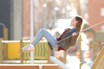 Profile of a happy girl swinging in a park