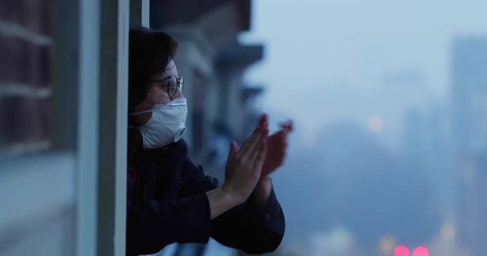 Quarantine in Europe, the coronavirus pandemic. People applaud health workers. Girl takes part in a flash mob. Celebration quarantine ending