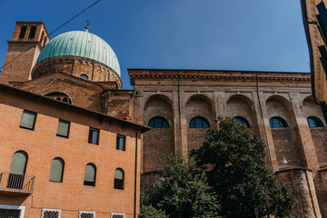 Fototapeta na wymiar The building is made of red stone with a large green dome against the blue sky on a Sunny day | VENICE, ITALY - 16 SEPTEMBER 2018. 