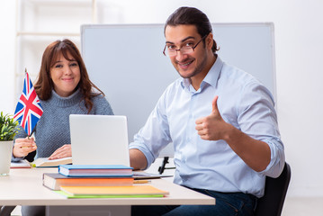 Obraz premium Young female student and male english teacher in the classroom