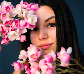 Gorgeous young girl with colorful cherry bloosome flowers, studio 