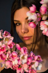 Gorgeous young girl with colorful cherry bloosome flowers, studio 