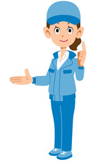 右側を紹介し人差し指を建てる青い作業着を着た女性
