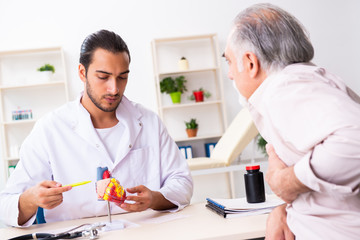 Obraz premium Old man visiting young male doctor cardiologist