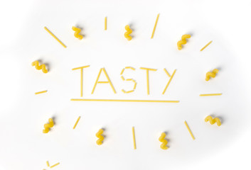 word "tasty" insde circle of pasta isolated white