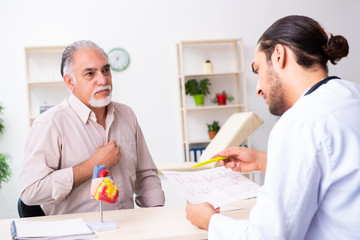 Old man visiting young male doctor cardiologist