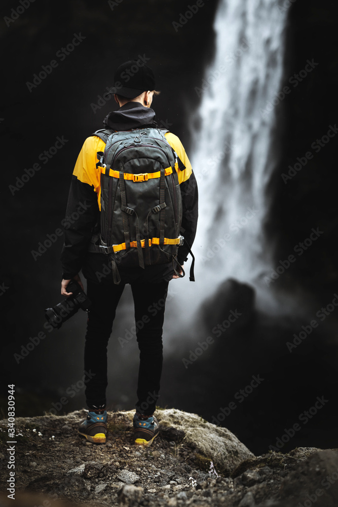 Wall mural traveler by a waterfall