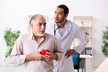 Old man visiting young male doctor cardiologist