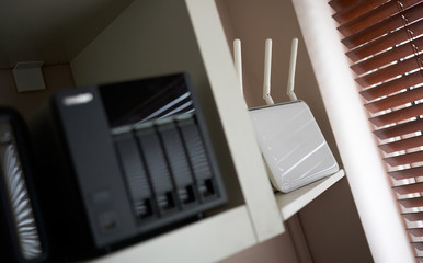 A white wireless modem router in a home office providing a gateway to the internet.
