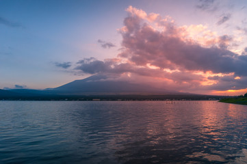 Sunset lake landscape with mount Fuji in the clouds on the background