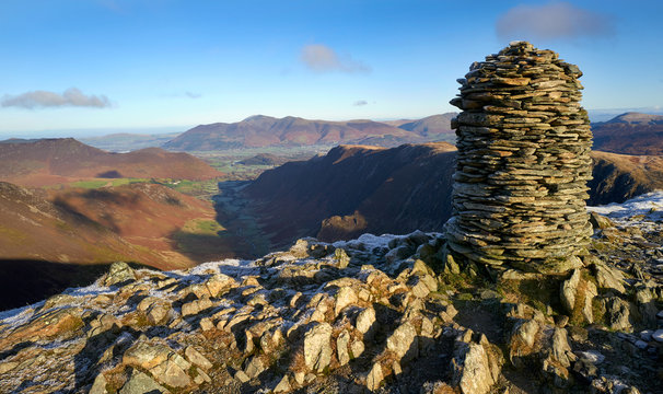 The frozen gound and Dale Head summit marker, Newlands Beck valley the mountains of High Crags, Maiden Moor & High Spy, the Derwent Fells in the winter Lake District, UK.