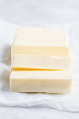 Sliced butter on paper white background.
