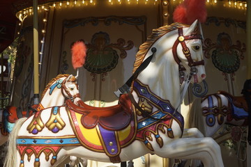 Fototapeta na wymiar Vintage merry-go-round with horses on a fairground. Venetian carousel with beautiful, vibrant colored horses.
