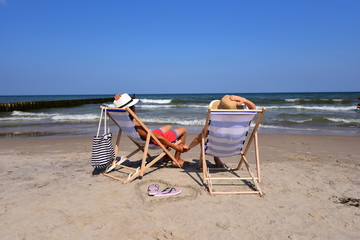 Para młodych zakochanych ludzi nad morzem podczas letniego urlopu odpoczywa na plaży