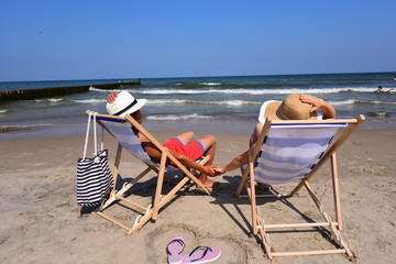 Summer camp. Relaks na plaży nad morzem podczas wakacji letnich, zakochani w walentynki trzymają...