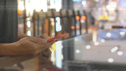 An upwardly mobile Asian Muslim man using a mobile phone - smartwatch to pay for a product at a sale terminal with nfc identification payment for verification and authentication