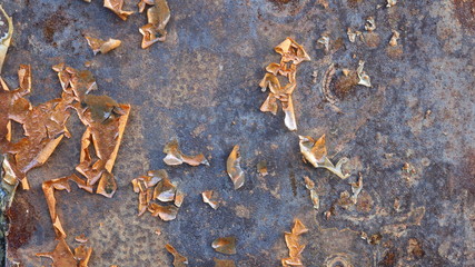 peeling paint remnants on an old rough, decrepit surface