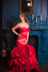 Redhead Woman in red luxury dress with feathers