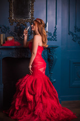 Redhead Woman in red luxury dress with feathers