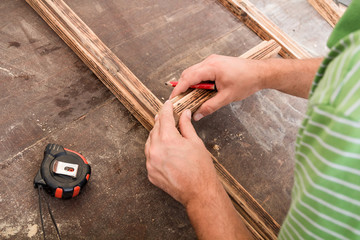 Male carpenter working on old wood in a retro vintage workshop.