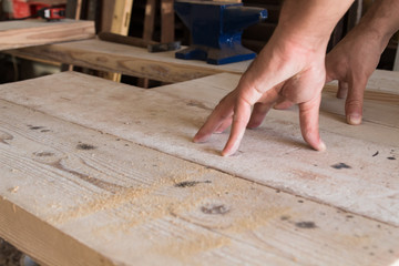 Male carpenter working on old wood in a retro vintage workshop.