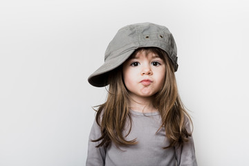 Une petite fille avec une casquette trop grande pour sa tête
