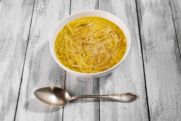 Domowy rosół na stole z desek z rustykalna łyżką © piotrszczepanek