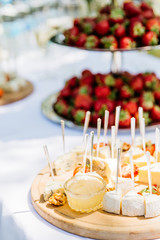 strawberry and cheese catering on a white table with glasses on the nature