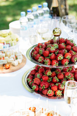strawberry and cheese catering on a white table with glasses on the nature