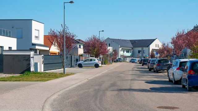 Brand New Residential Houses With Car Parked On Driveway In Front. Newly Built Modern Residential Park With Cars And Trees.Blue Sky.