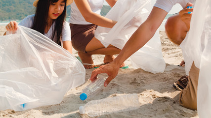 Asian young happy family activists collecting plastic waste on beach. Asia volunteers help to keep nature clean up and pick up garbage. Concept about environmental conservation pollution problems.