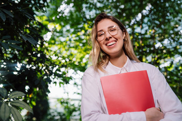 Fototapeta premium Young female agricultural engineer working in greenhouse.