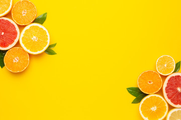 Citruses fruits on yellow background with copyspace, fruit flatlay, summer minimal compositon with grapefruit, lemon, mandarin and orange