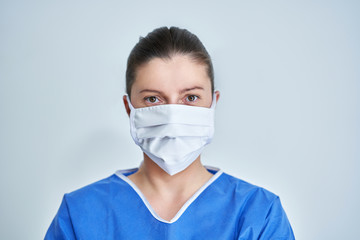 Close up portrait of female medical doctor or nurse wearing protective mask
