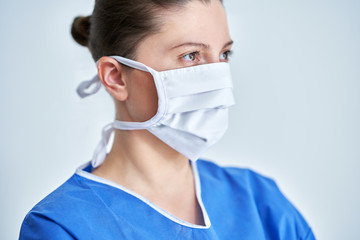 Close up portrait of female medical doctor or nurse wearing protective mask