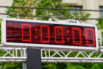 Outdoor time panel display for competitors set up on a metallic surface, ready to show the start for a marathon running event, zero hours, minutes and seconds
